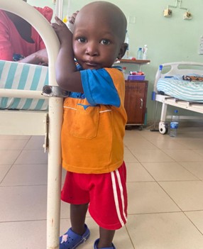 Masunga, a young boy hugging a bed
